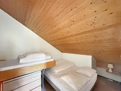 a small room with a bed and a wooden ceiling at OB222 - 2 pièces Mezzanine 6 pers pieds de pistes in Les Carroz d'Araches