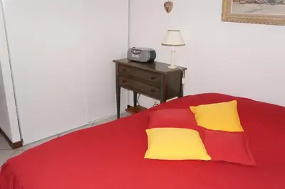 a bed with red and yellow pillows and a table at SB106 - 2 Pièces 5/6 Pers centre des Carroz in Les Carroz d'Araches