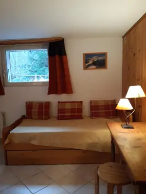 a bedroom with a bed with a window and a table at Le Bivouac in Chamonix-Mont-Blanc
