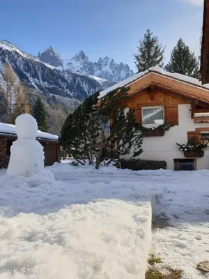 a snowman in front of a house in the snow at Le Bivouac in Chamonix-Mont-Blanc