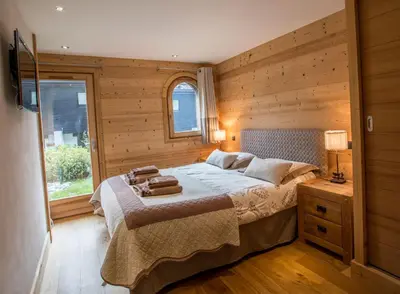 a bedroom with a bed with a wooden wall at Chalet 1155 - Montroc - Chamonix in Chamonix-Mont-Blanc