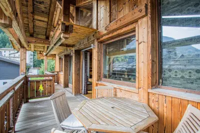 a wooden porch with a wooden table and chairs at Chalet 1155 - Montroc - Chamonix in Chamonix-Mont-Blanc