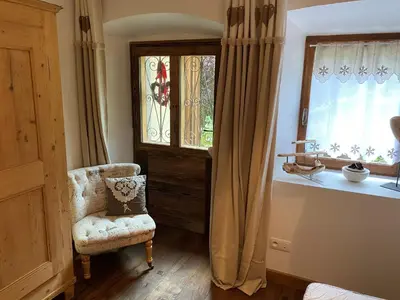 a bedroom with a chair next to a window at Chalet Le Triollet in Saint-Gervais-les-Bains