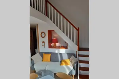a living room with a couch and a staircase at Eden Roc Grand Massif in Les Carroz d'Araches