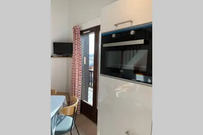 a kitchen with a stove and a microwave at Eden Roc Grand Massif in Les Carroz d'Araches