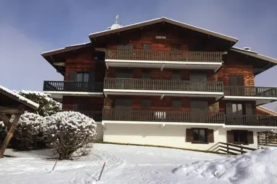 a large wooden building with snow in front of it at Eden Roc Grand Massif in Les Carroz d'Araches