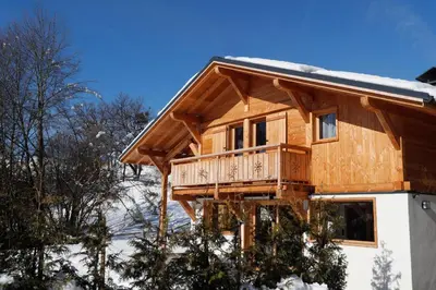 a log cabin with a balcony in the snow at Prestigious Chalet in Saint-Gervais-les-Bains