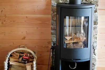 a wood burning stove in a room with a wall at Prestigious Chalet in Saint-Gervais-les-Bains