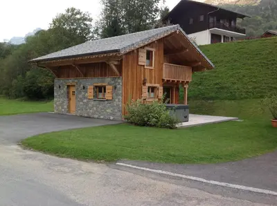 a small wooden building with a porch in a yard at L'Erine des Alpes SPA Chalet individuel grand confort in Sixt