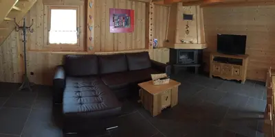 a living room with a couch and a television at L'Erine des Alpes SPA Chalet individuel grand confort in Sixt