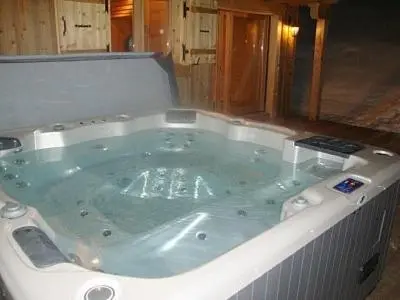 a large jacuzzi tub in a wooden room at L'Erine des Alpes SPA Chalet individuel grand confort in Sixt