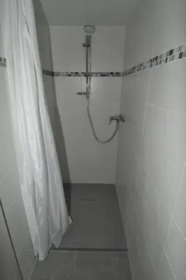 a shower in a white bathroom with a shower curtain at Face Mont-Blanc in Passy