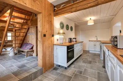 a kitchen with white appliances and wooden walls at La ferme des ours in Saint-Gervais-les-Bains