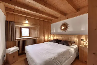 a bedroom with a large bed in a wooden room at La ferme des ours in Saint-Gervais-les-Bains