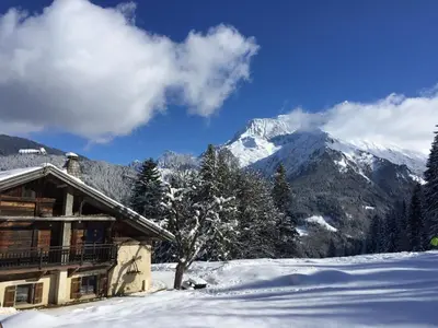 a cabin in the snow with a snow covered mountain at La ferme des ours in Saint-Gervais-les-Bains