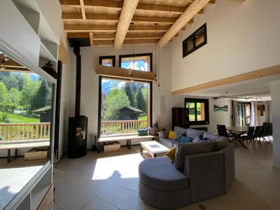 a living room with a couch and a large window at Chalet Mountain Vibes in Les Houches