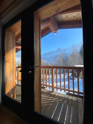 a window in a cabin with a view of the mountains at Chalet Mountain Vibes in Les Houches