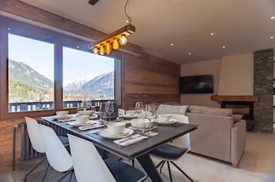 a dining room with a table and chairs and a couch at Apartment Brevent Fodera in Chamonix-Mont-Blanc