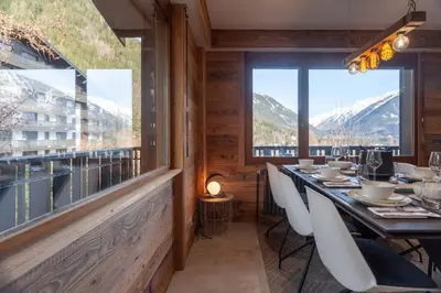 a dining room with a table and views of mountains at Apartment Brevent Fodera in Chamonix-Mont-Blanc