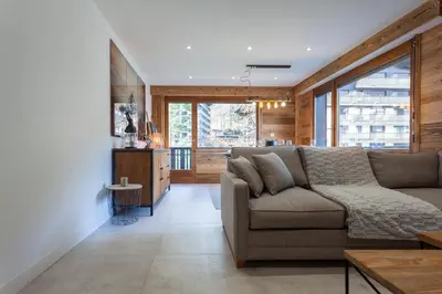 a living room with a couch and a large window at Apartment Brevent Fodera in Chamonix-Mont-Blanc