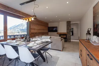 a dining room and living room with a table and chairs at Apartment Brevent Fodera in Chamonix-Mont-Blanc