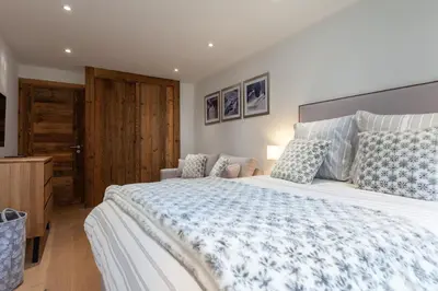 a bedroom with a large bed with blue and white sheets at Apartment Brevent Fodera in Chamonix-Mont-Blanc