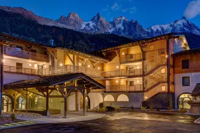 a large building with mountains in the background at Résidence Luxe 5*,Spa & Fitness, La Cordée Appartement 821 in Chamonix-Mont-Blanc