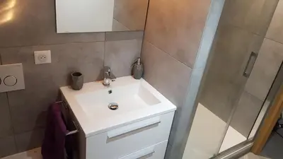 a bathroom with a white sink and a shower at Résidence Luxe 5*,Spa & Fitness, La Cordée Appartement 821 in Chamonix-Mont-Blanc