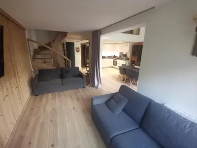 a living room with a blue couch and a kitchen at Résidence Luxe 5*,Spa & Fitness, La Cordée Appartement 821 in Chamonix-Mont-Blanc