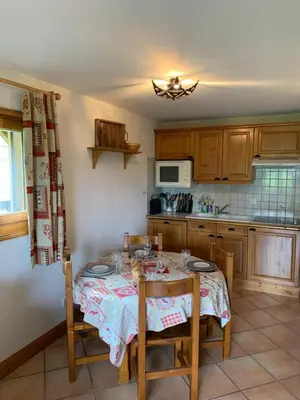 a kitchen with a table with chairs and a kitchen with at La clé des montagnes in Les Houches