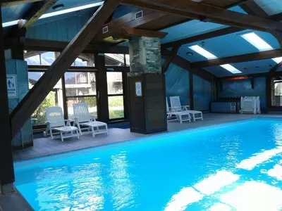 a large swimming pool with chairs in a building at La clé des montagnes in Les Houches