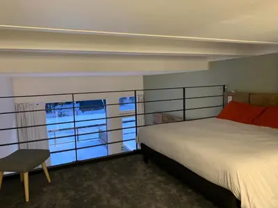 a bedroom with a bed and a chair and a window at Flaine Forum L1 Cassiopée Mezzanine & Terrasse in Flaine