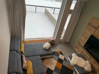 a living room with a couch and a large window at Flaine Forum L1 Cassiopée Mezzanine & Terrasse in Flaine