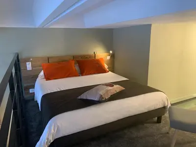 a bedroom with two beds with orange pillows at Flaine Forum L1 Cassiopée Mezzanine & Terrasse in Flaine