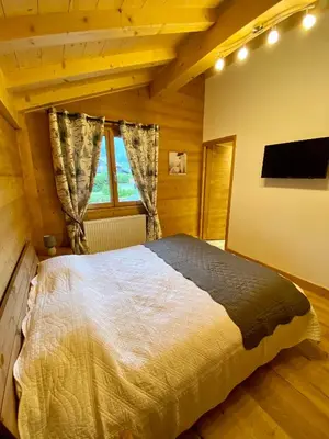 a bedroom with a large bed in a room at Chalet luxe L'HIBISCUS in Samoëns