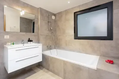 a bathroom with a tub and a tv on the wall at La Cordee 612 apartment- Chamonix All Year in Chamonix-Mont-Blanc