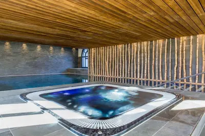 a swimming pool with a blue tub in a room at La Cordee 612 apartment- Chamonix All Year in Chamonix-Mont-Blanc