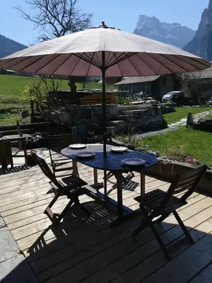 a table and two chairs under an umbrella at LA FERME DU FAY in Sixt