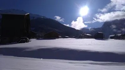 a snow covered field with the sun in the sky at LA FERME DU FAY in Sixt