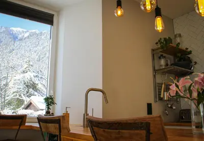 a kitchen with a table and a window with a mountain view at Apartment Chinook,La Praz,Chamonix Mont Blanc in Chamonix-Mont-Blanc