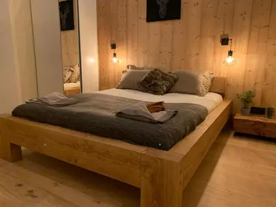 a large wooden bed in a room with wooden walls at Apartment Chinook,La Praz,Chamonix Mont Blanc in Chamonix-Mont-Blanc