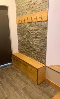 a wooden bench in front of a brick wall at Apartment Chinook,La Praz,Chamonix Mont Blanc in Chamonix-Mont-Blanc