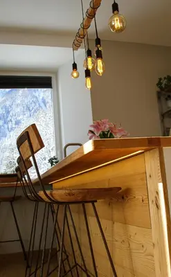 a dining room table with a chair and lights at Apartment Chinook,La Praz,Chamonix Mont Blanc in Chamonix-Mont-Blanc
