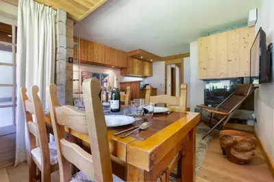 a dining room with a wooden table and a fireplace at Residence Amethystes in Chamonix-Mont-Blanc