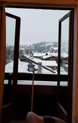 a window with a view of a snow covered city at Le Duplex Septimontain in Samoëns