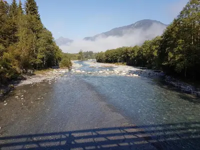 a river with snow on the side of it at Le Duplex Septimontain in Samoëns