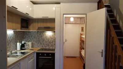 a small kitchen with a sink and a staircase at Le Duplex Septimontain in Samoëns