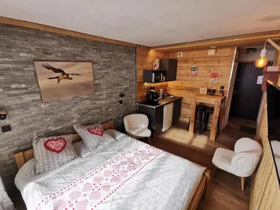 a bedroom with a large bed and a kitchen at Le Gypaète in Chamonix-Mont-Blanc