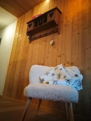 a chair in a room with a wooden wall at Le Gypaète in Chamonix-Mont-Blanc