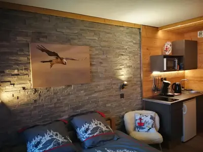 a room with a brick wall with a bird painting on the wall at Le Gypaète in Chamonix-Mont-Blanc